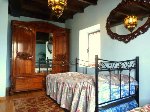 a bedroom with a bed and a mirror at Casa rural El Tejo in Bermiego