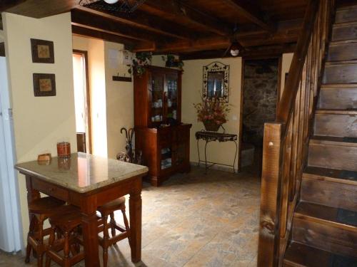 Casa rural El Tejo في Bermiego: مطبخ مع طاولة وكراسي في غرفة