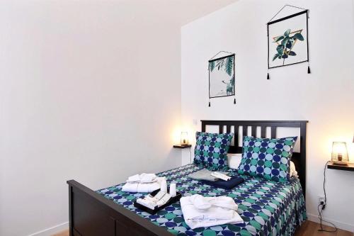 une chambre avec un lit avec des draps bleus et blancs dans l'établissement APPARTEMENT NEUF HYPER CENTRE _ SAINT FERREOL, à Marseille