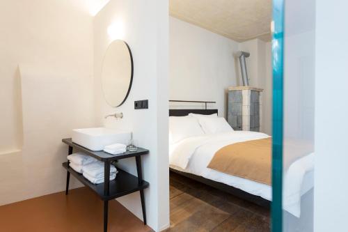 a bedroom with a bed and a sink and a mirror at Goldenstern Townhouse in Bolzano