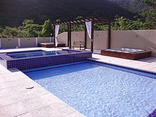 una piscina con una mesa y una silla. en Pousada Recanto dos Feijós, en Florianópolis