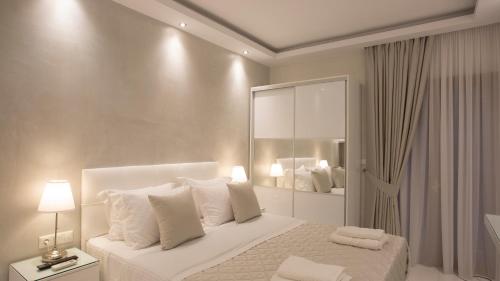 a white bedroom with a bed with white pillows at Amaryllis Luxury Rooms in Platamonas