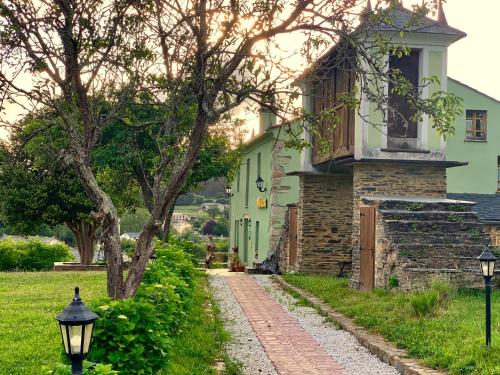 une maison avec une terrasse couverte et une passerelle dans l'établissement Os Tres Teixos, à San Acisclo