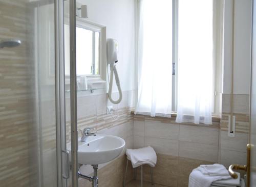 a white bathroom with a sink and a shower at Hotel Club i Pini - Residenza d'Epoca in Versilia in Lido di Camaiore