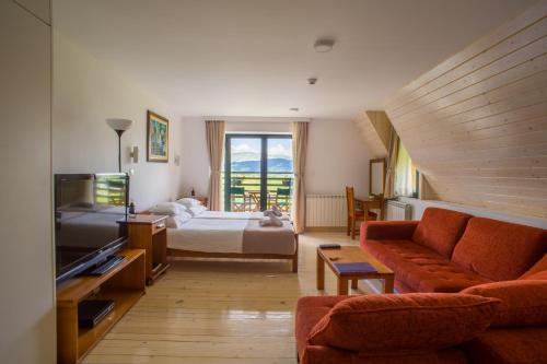 a living room with a bed and a couch at Hotel Polar Star in Žabljak