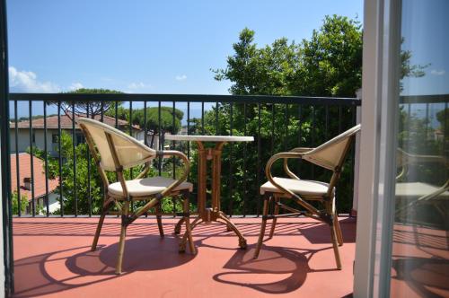 two chairs and a table on a balcony at Hotel Club i Pini - Residenza d'Epoca in Versilia in Lido di Camaiore