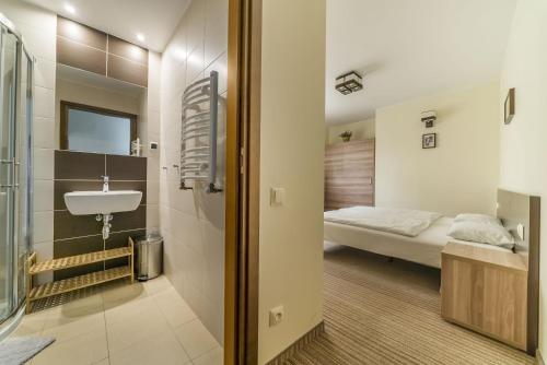 a bathroom with a sink and a bed in a room at Willa Vela in Władysławowo