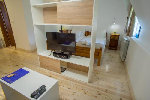 a small room with a bed and a television at Hotel Polar Star in Žabljak