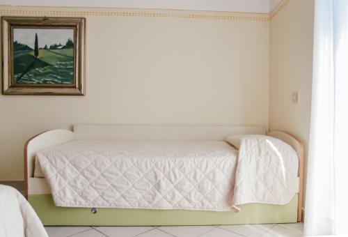 a bed in a room with a picture on the wall at Hotel Club i Pini - Residenza d'Epoca in Versilia in Lido di Camaiore