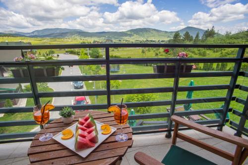 a table with a plate of fruit on a balcony at Hotel Polar Star in Žabljak