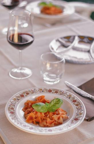 a plate of food on a table with wine glasses at Hotel Club i Pini - Residenza d'Epoca in Versilia in Lido di Camaiore