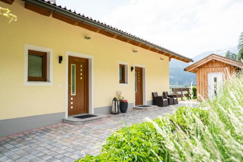 a yellow house with a patio in front of it at Appartements Salentinig in Flattach