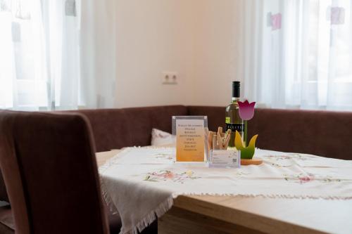 a table with a white table cloth and a bottle of wine at Appartements Salentinig in Flattach