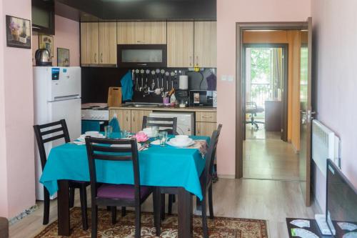 a kitchen with a table with a blue table cloth at Apartment Eve in Varna City
