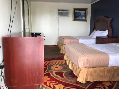Habitación de hotel con 2 camas y mesa en Sunset Inn, en Atlantic City