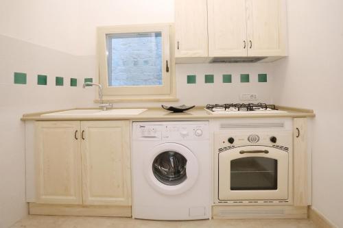 a kitchen with a washing machine and a sink at Villa Rosato in Selva di Fasano