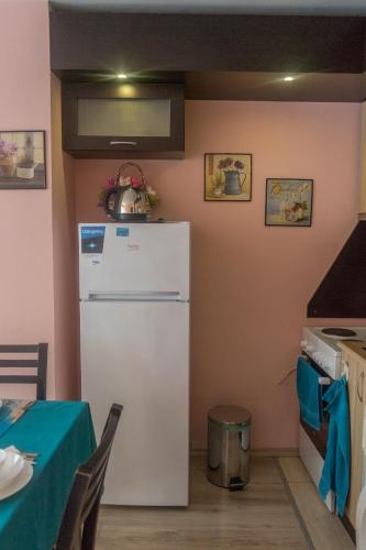 a kitchen with a white refrigerator and a table at Apartment Eve in Varna City