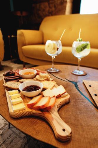 a table with a tray of cheese and two wine glasses at Borralha Hotel, Restaurante & Spa in Vila Real