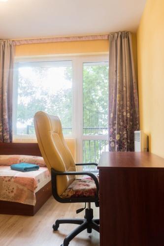 a bedroom with a desk and a chair and a window at Apartment Eve in Varna City