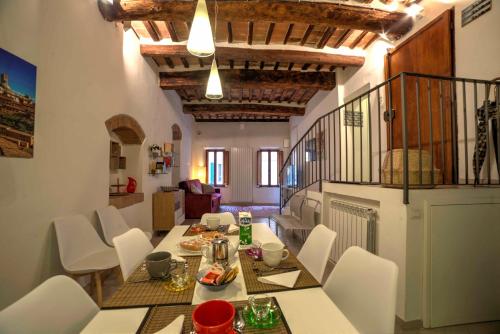 a dining room with a table and white chairs at Cozy Apartment in the heart of Siena in Siena