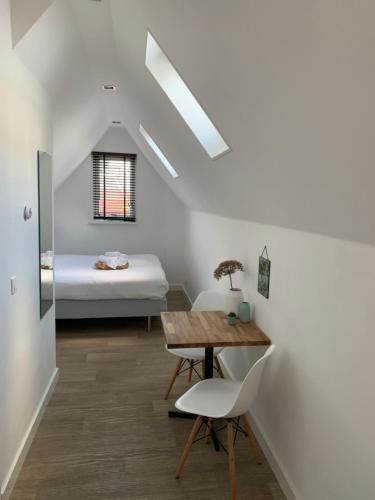 a room with a bed and a table and chairs at Koningshof in Alkmaar