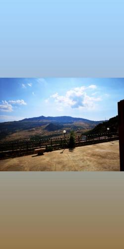 two pictures of a view of a field with a fence at MonteSoprano Agriturismo - Resort - Spa - Gym -Camping - Suite in Capizzi