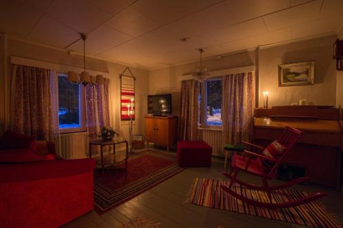 een woonkamer met een rode bank en stoelen bij Villa Havula in Ranua