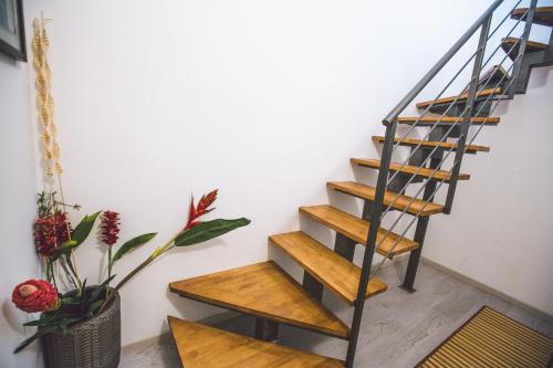 a staircase with wooden steps in a room with plants at Hotel Como in Siracusa