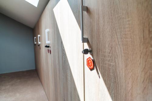 a hallway with wooden doors with a red button on it at VALIZA HOSTEL in Uzhhorod