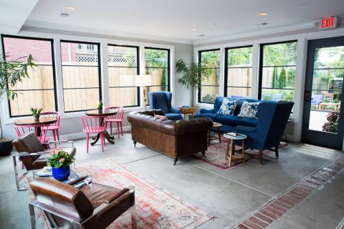 a living room with couches and chairs and windows at The Germantown Inn in Nashville