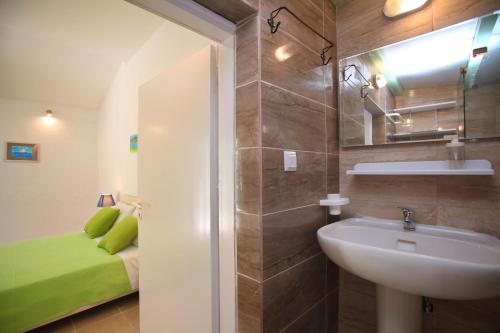 un bagno con lavandino, servizi igienici e un letto di Liogerma Cottage a Panormos Skopelos
