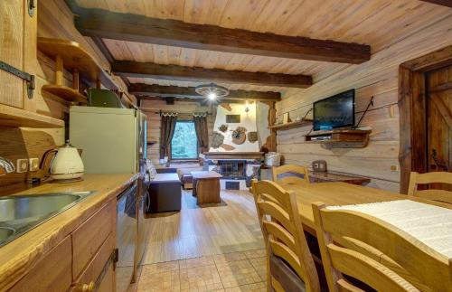 a kitchen and living room in a log cabin at Prie Klykio in Utena