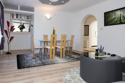a dining room and living room with a table and chairs at Apartman Mirko in Otočac