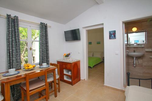 ein Wohnzimmer mit einem Tisch und ein Zimmer mit einem Schlafzimmer in der Unterkunft Liogerma Cottage in Panormos Skopelos