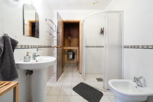 a white bathroom with a sink and a shower at Old Town - Viru Gate Apartment in Tallinn