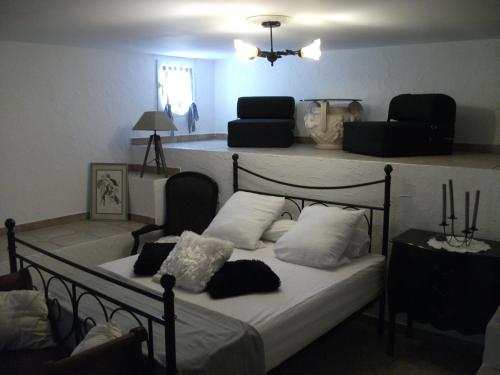 a bedroom with a bed with white sheets and pillows at T2 dans la région Bastiaise vue sur la mer in Furiani