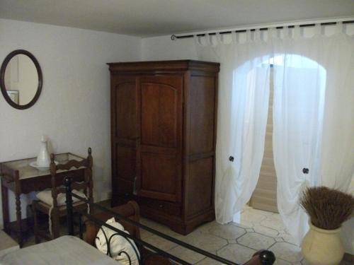 ein Wohnzimmer mit einem Holzschrank und einem Spiegel in der Unterkunft T2 dans la région Bastiaise vue sur la mer in Furiani