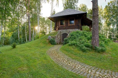 a log cabin on a hill with a stone path at Prie Klykio in Utena