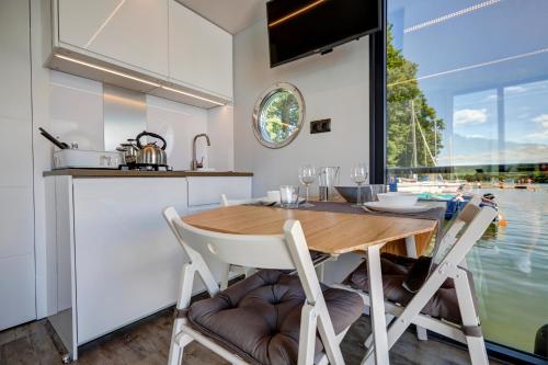 eine Küche und ein Esszimmer mit einem Holztisch und Stühlen in der Unterkunft Apartament Na Wodzie in Ruciane-Nida