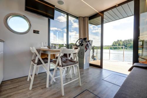 a dining room with a table and chairs and a large window at Apartament Na Wodzie in Ruciane-Nida