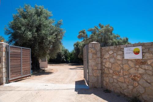 a gate in a stone wall next to a dirt road at Summer Dream Lefkas in Lefkada Town