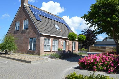 uma casa de tijolos com painéis solares no telhado em Veugelvrie em Kamperland