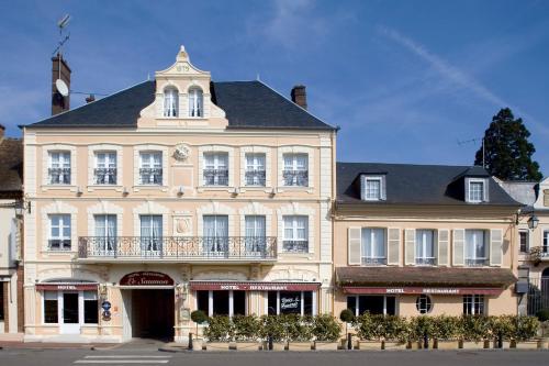 un grande edificio con una torre dell'orologio sopra di Hotel du Saumon, Verneuil sur Avre a Verneuil d'Avre et d'Iton