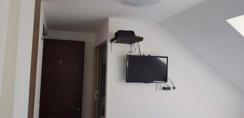 a tv hanging on a wall in a room at Duna Dráva Vendégház in Érsekcsanád