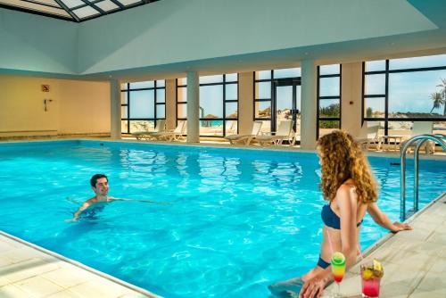 a boy and a girl in a swimming pool at Ulysse Thalasso & Spa - All Inclusive in Houmt Souk