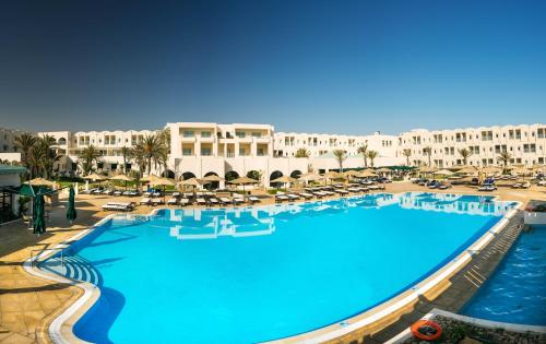 a large swimming pool in a resort with lounge chairs at Ulysse Thalasso & Spa - All Inclusive in Houmt Souk
