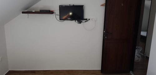a room with a tv on a white wall at Duna Dráva Vendégház in Érsekcsanád