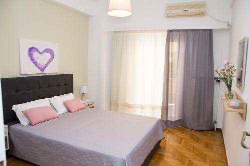 a bedroom with a bed with two pink pillows at Acropolis,Historic center Apartment-update in Athens