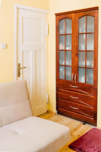 a living room with a couch and a wooden door at pokój na Monciaku in Sopot