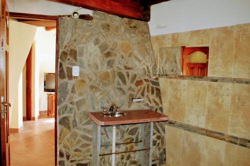baño con lavabo y pared de piedra en Cabañas La Comarca del Hobit in 